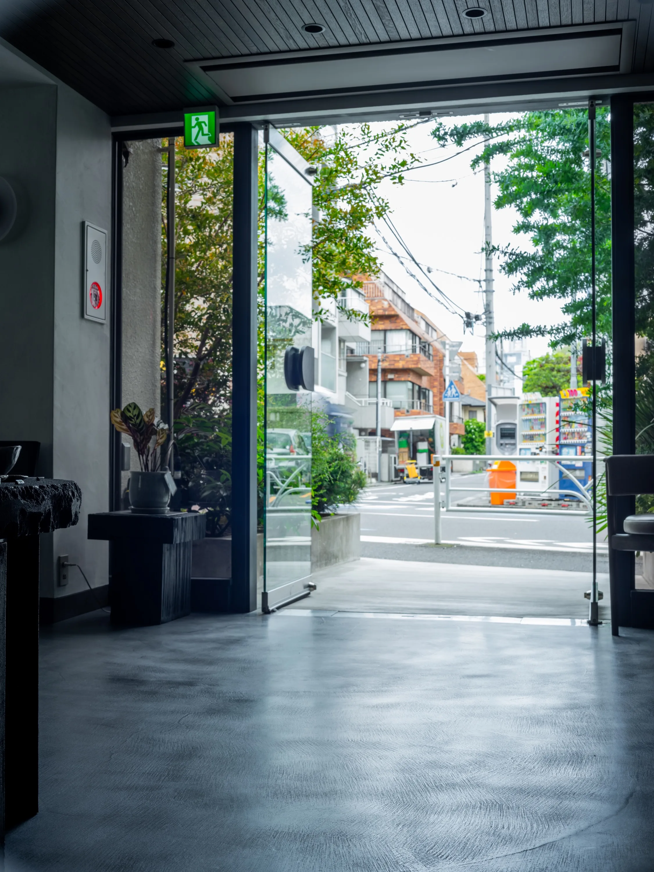 開いたガラスの入口越しに見える店外の街並み